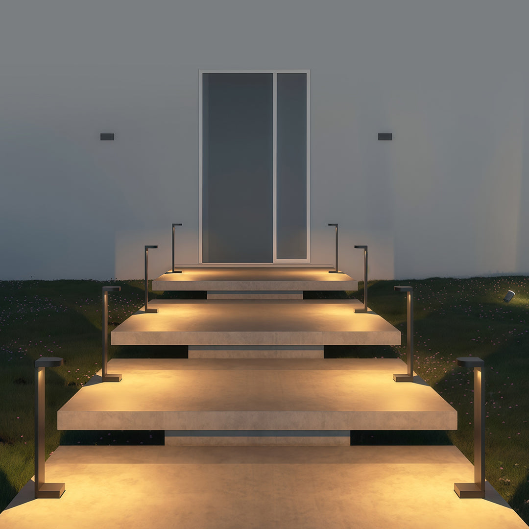 Landscape pathway light near a garden with shrubs, adding a contemporary touch to the outdoor space.