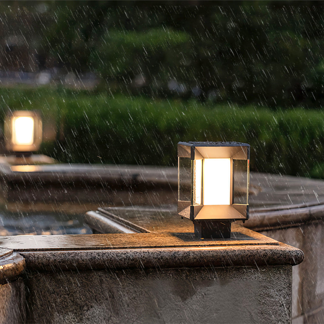 Pillar lights outdoor modern installed on stone posts in a landscaped yard.