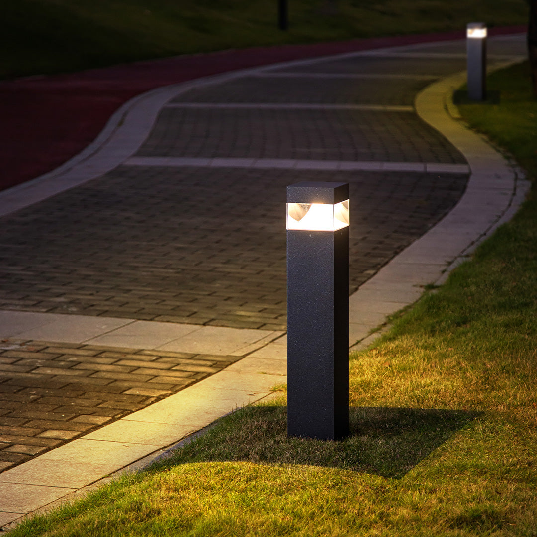 Architectural square bollards illuminating landscaped plaza area with contemporary design