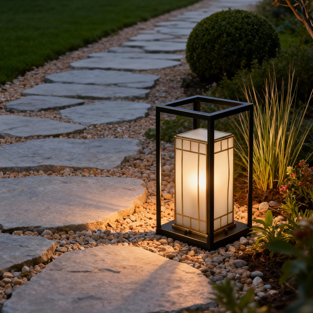Lantern bollard light installed along a stone garden path, providing warm and welcoming illumination for nighttime walkways.