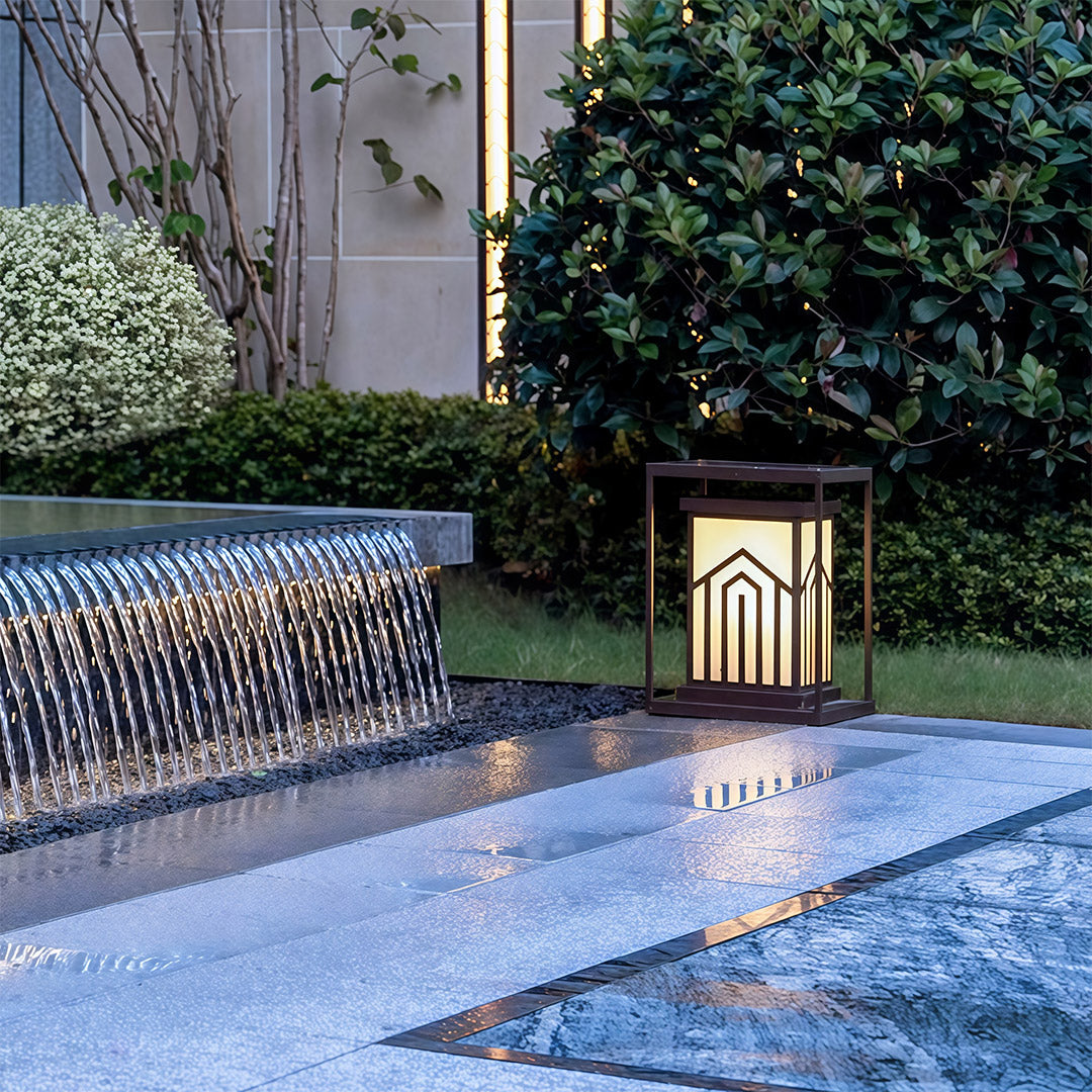 Lantern-style outdoor light beside a water feature, enhancing the peaceful ambiance of the outdoor setting.