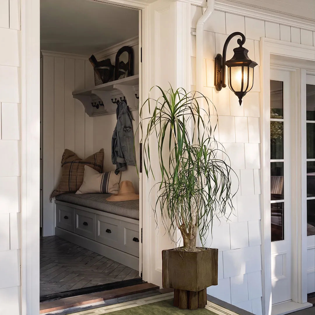Lantern outdoor wall lights installed beside a bright covered entry with classic black metal detailing.