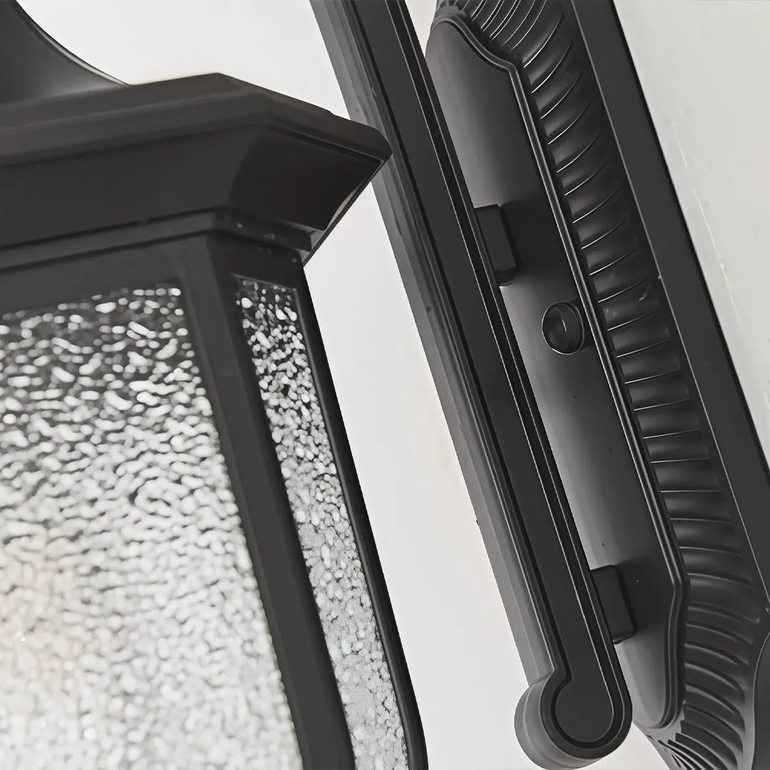 Lantern outdoor wall lights close-up showing textured seeded glass and detailed black metal construction.