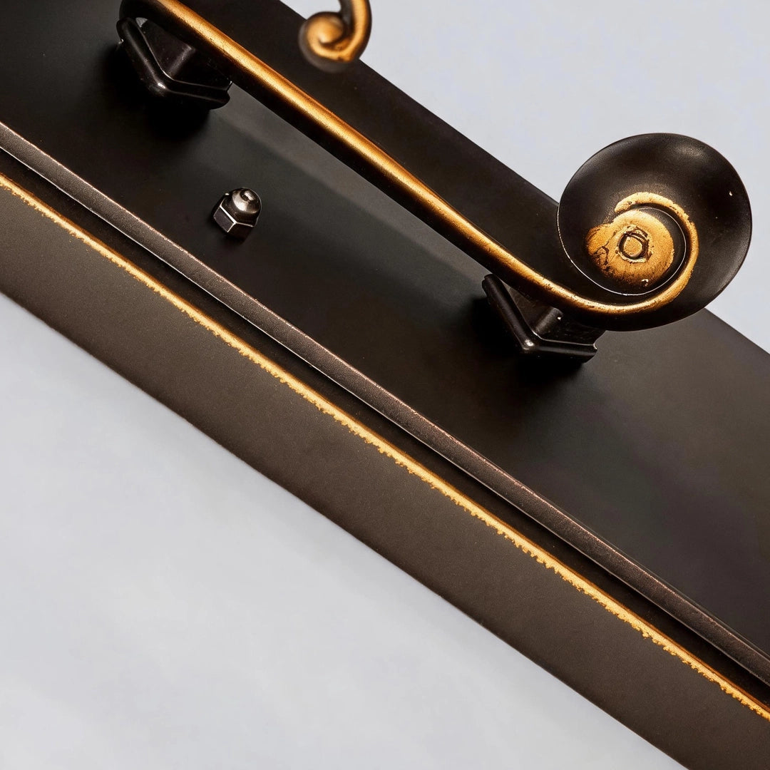 Lantern pillar lights close-up of the bronze mounting base with curled accent arm and antique finish.