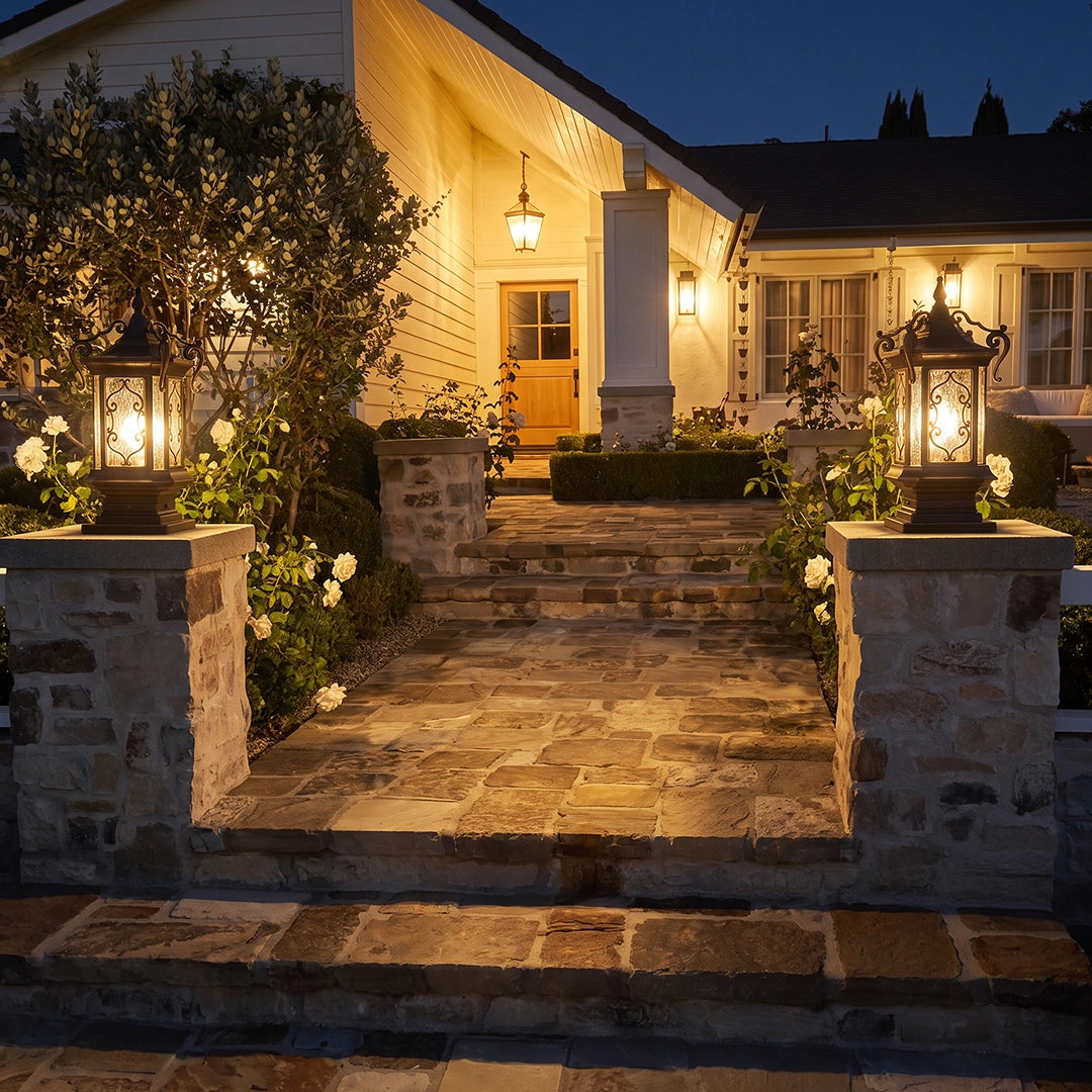 Lantern pillar lights illuminating a front entry walkway with matching fixtures mounted on stone gate posts.