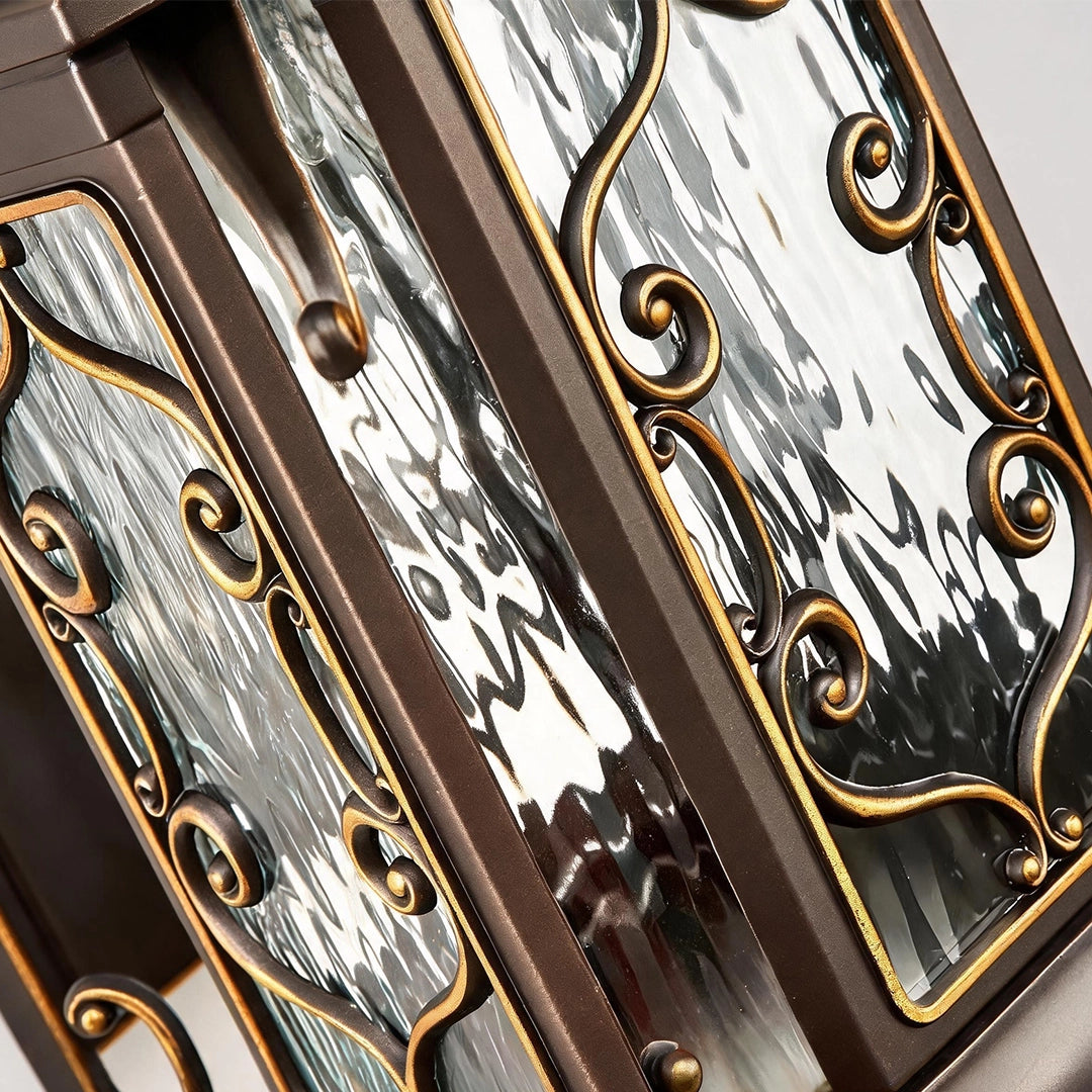 Lantern pillar lights close-up of seeded glass side panels with ornate bronze scroll detailing.