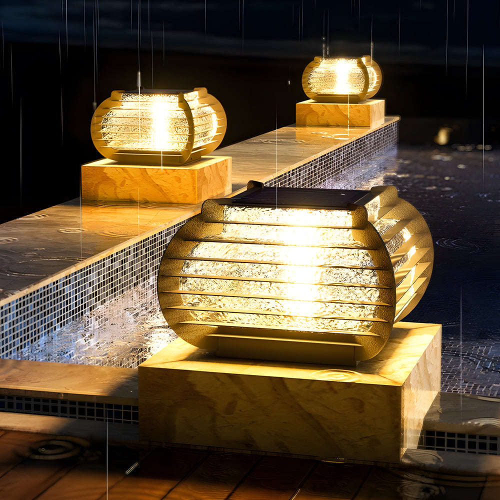 Lantern pillar lights installed along a pool edge, enhancing nighttime safety and visual appeal with warm glow.