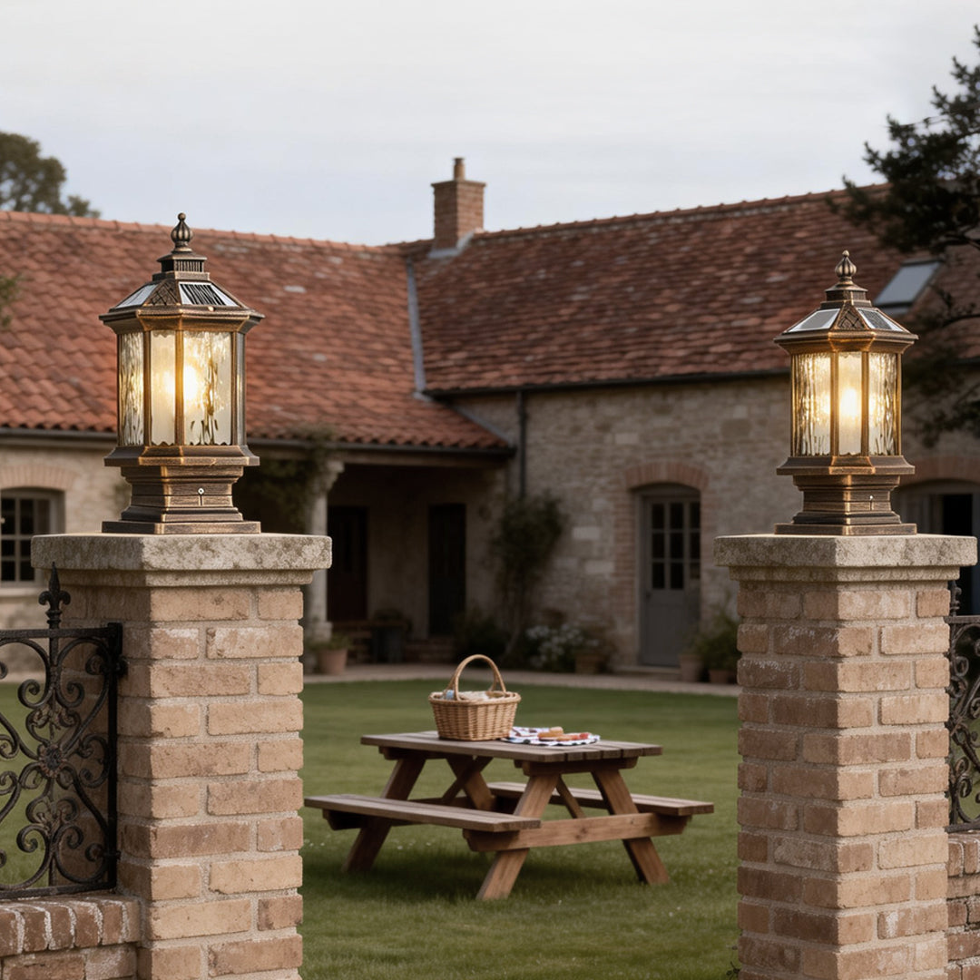 Lantern pillar lights mounted on a stone pillar, enhancing the rustic charm of a garden gate.