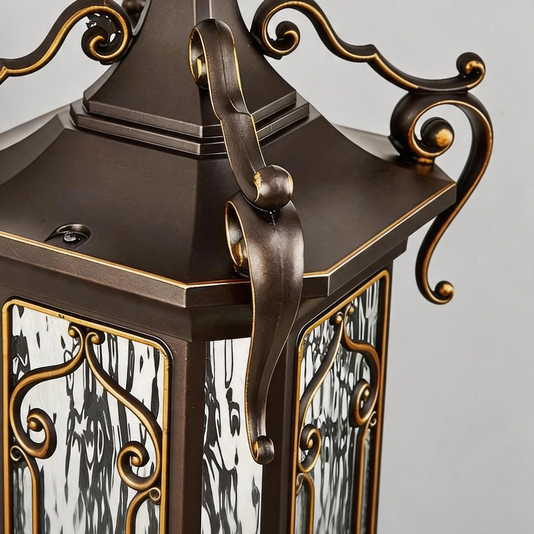 Lantern pillar lights close-up of the top cap and decorative scrollwork in a bronze outdoor post light design.