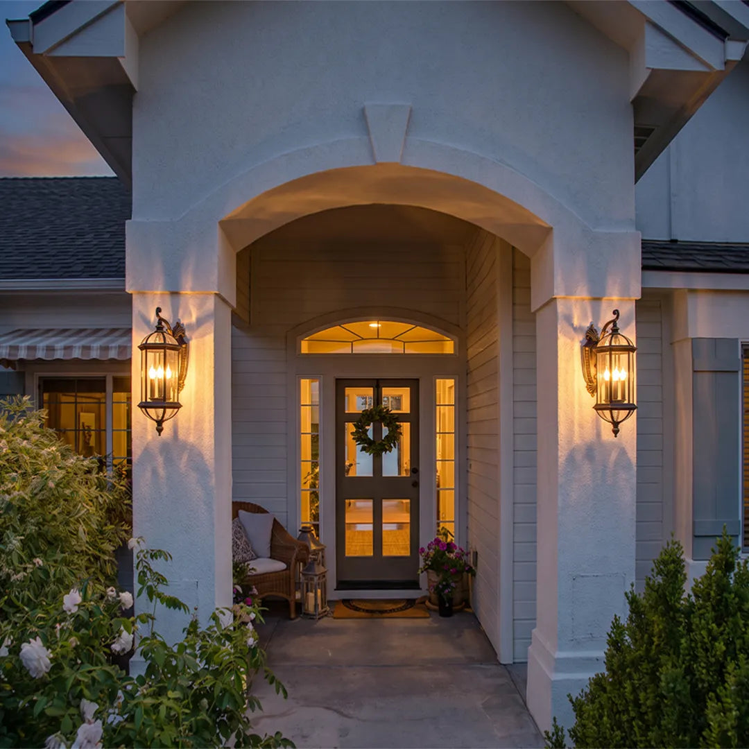 Lantern style outdoor wall lights flanking a front entry porch, bringing symmetrical illumination to the covered doorway.
