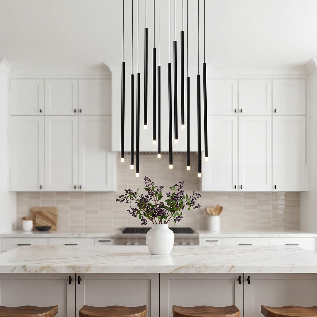Large black staircase chandelier staggered over a modern white marble kitchen island surfaces.