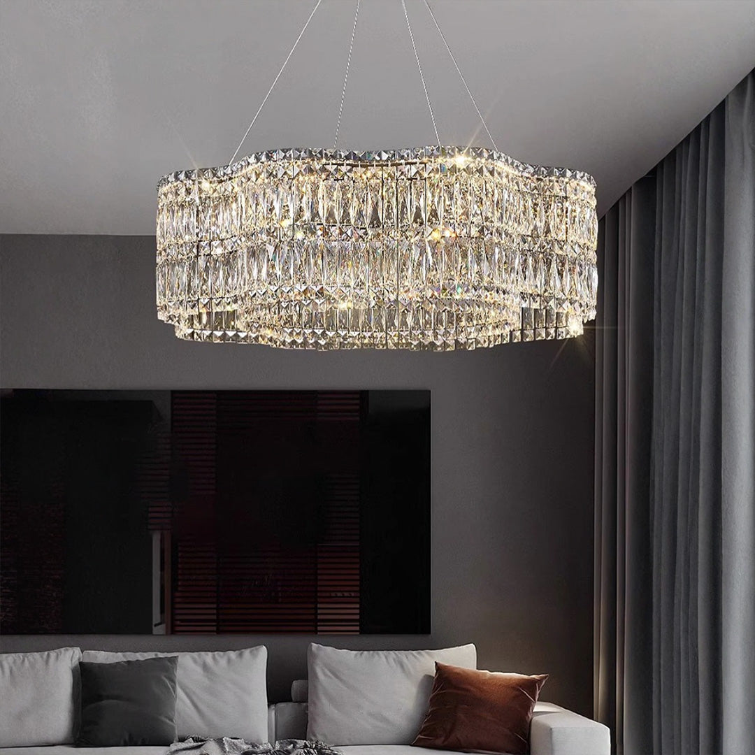 Large crystal chandelier with a gold frame, displayed in a minimalist interior with a white background.