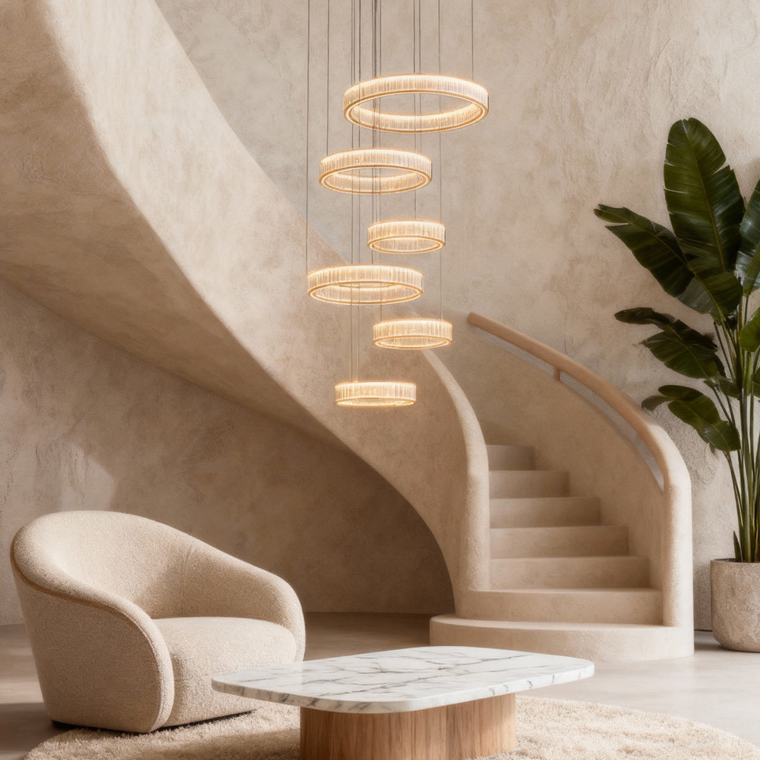 Large crystal chandeliers cascading along curved stairwell in contemporary space with neutral palette and modern furnishings