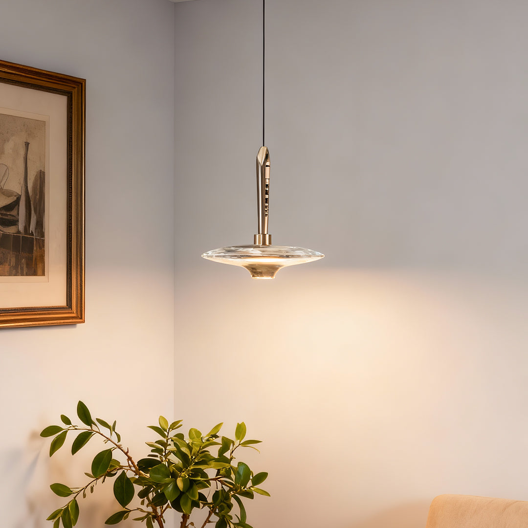 Large crystal pendant light illuminating entryway with warm glow above wooden console and botanical decor
