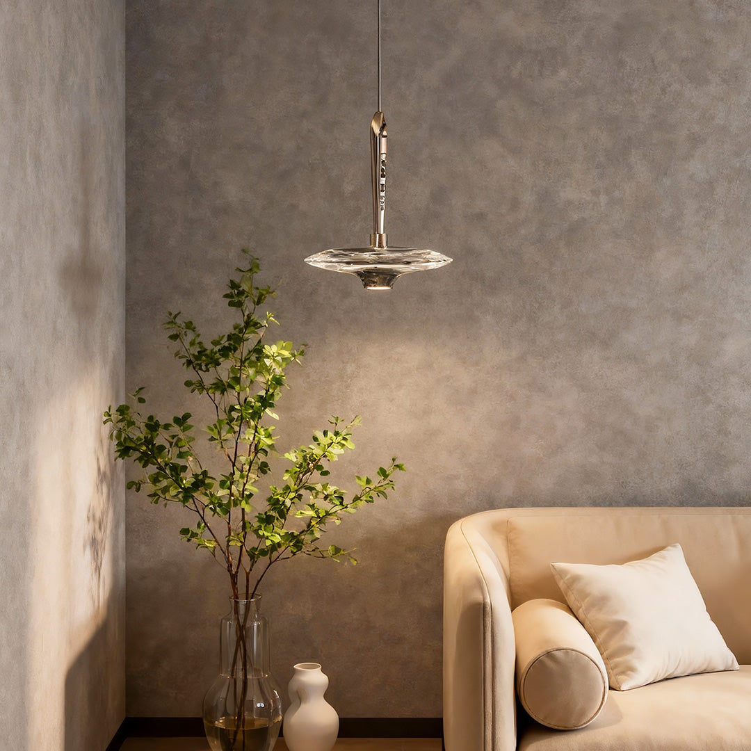 Large crystal pendant light suspended in living room with textured concrete walls and neutral contemporary furnishings