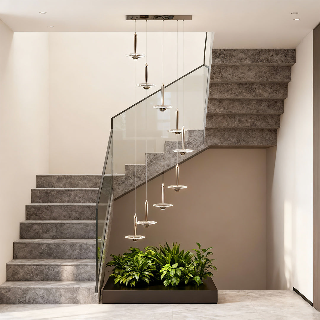 Large crystal pendant light creating dramatic focal point in modern stairwell with industrial concrete and greenery