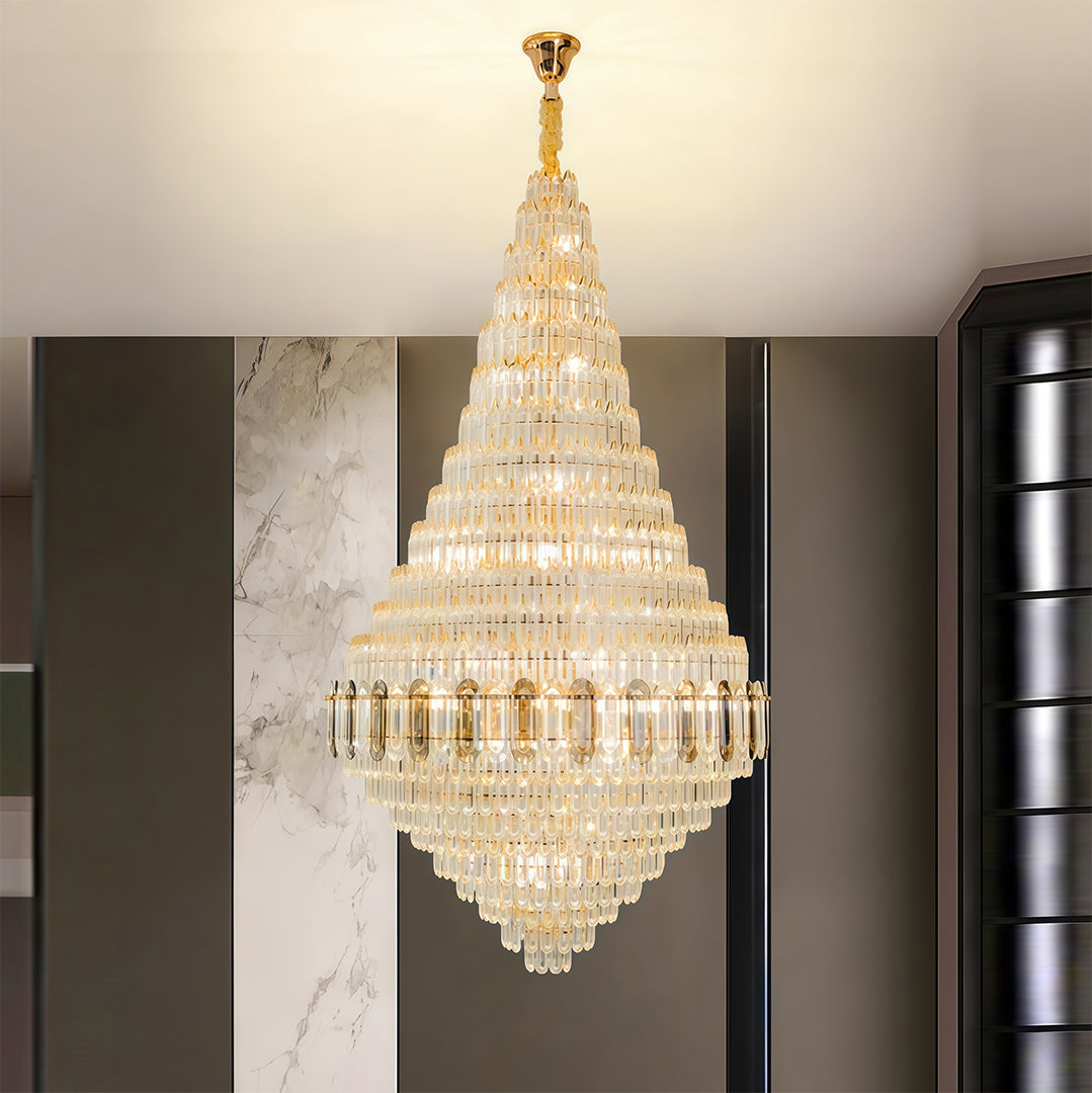 Large gold chandelier brightening modern hallway with dark architectural elements and neutral tones.