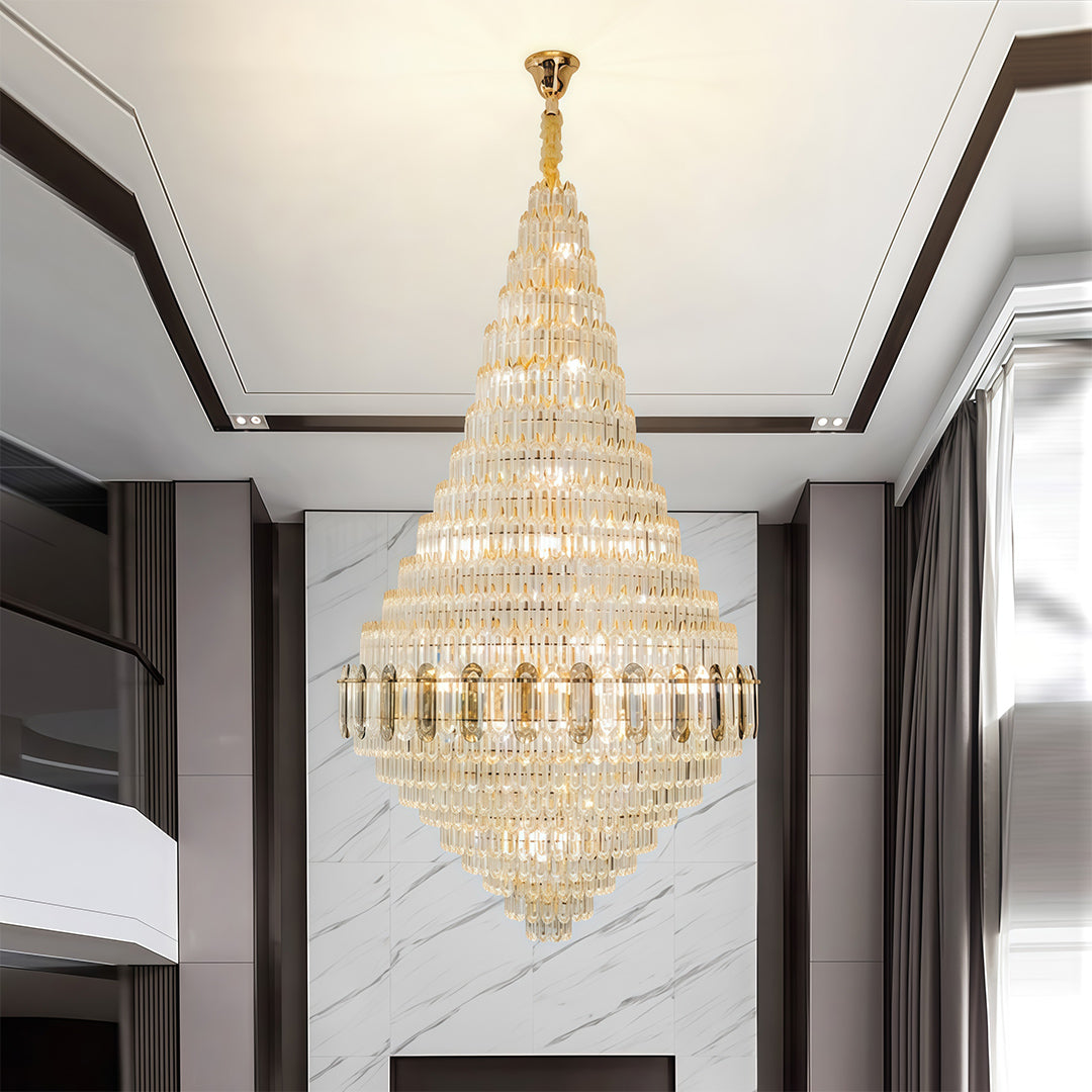 Large gold chandelier providing statement lighting in minimalist corridor with black framing and white walls.