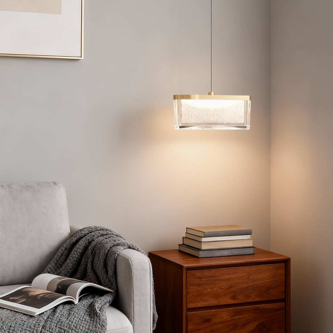 Large metal pendant lights mounted above nightstand in contemporary bedroom with gray textured walls and neutral bedding