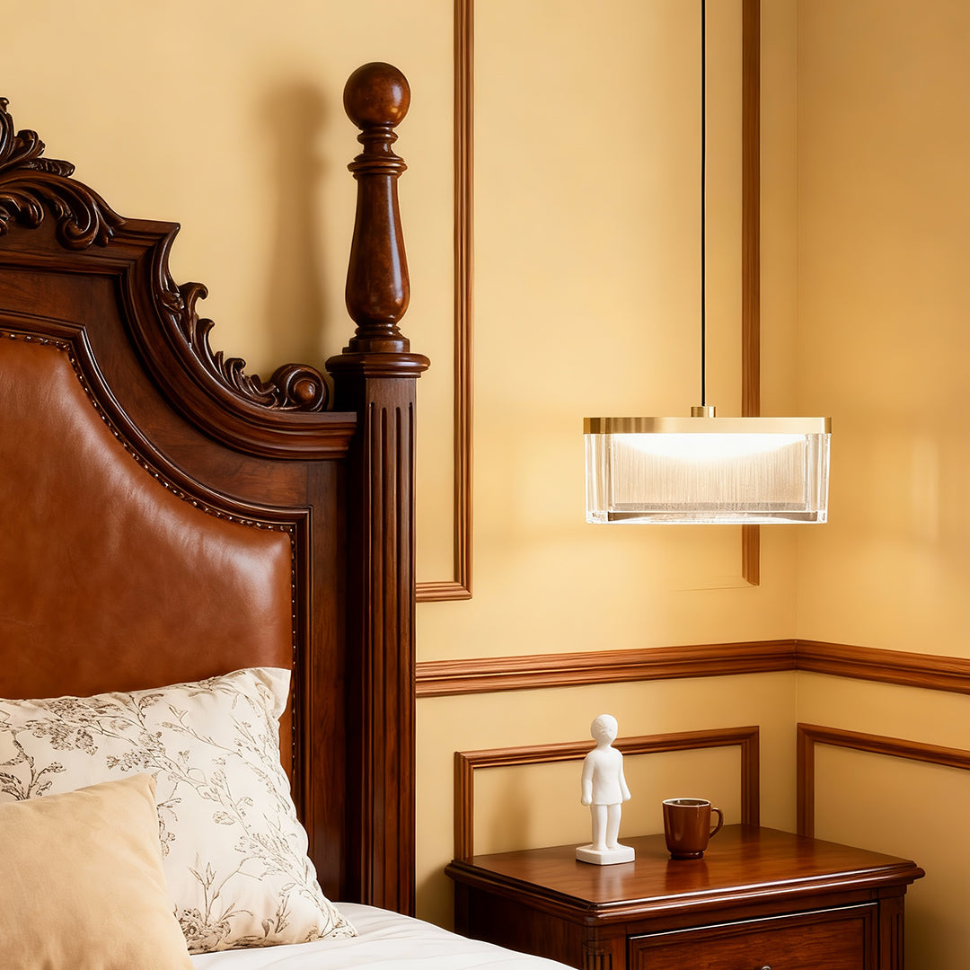 Large metal pendant lights providing warm illumination beside ornate wooden bed frame in traditional bedroom setting