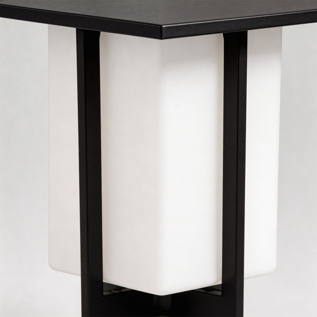 Minimalist large outdoor pillar light with white lampshade and black frame in a modern setting.
