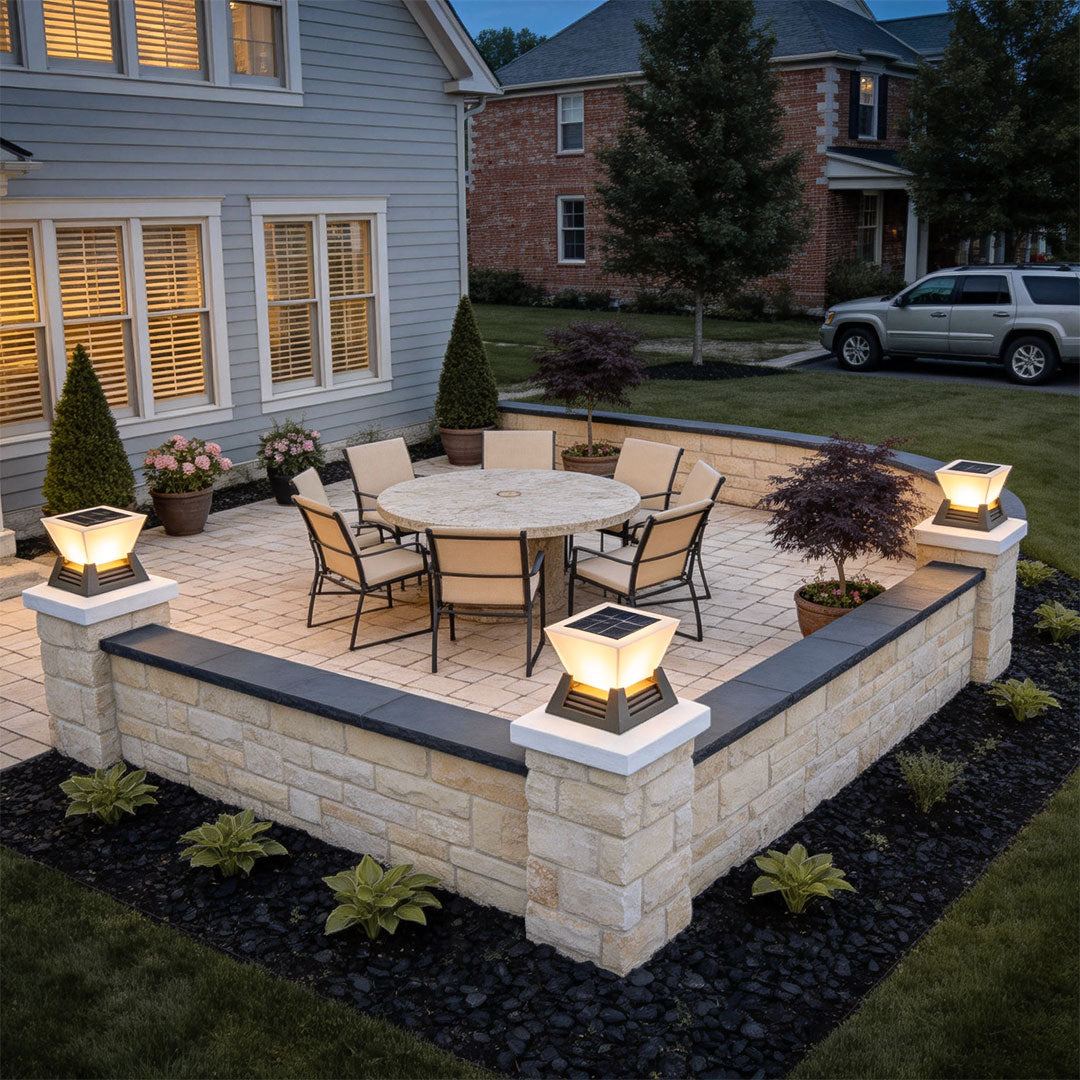 Large pillar lights illuminating an outdoor patio with stone seating and garden decor.