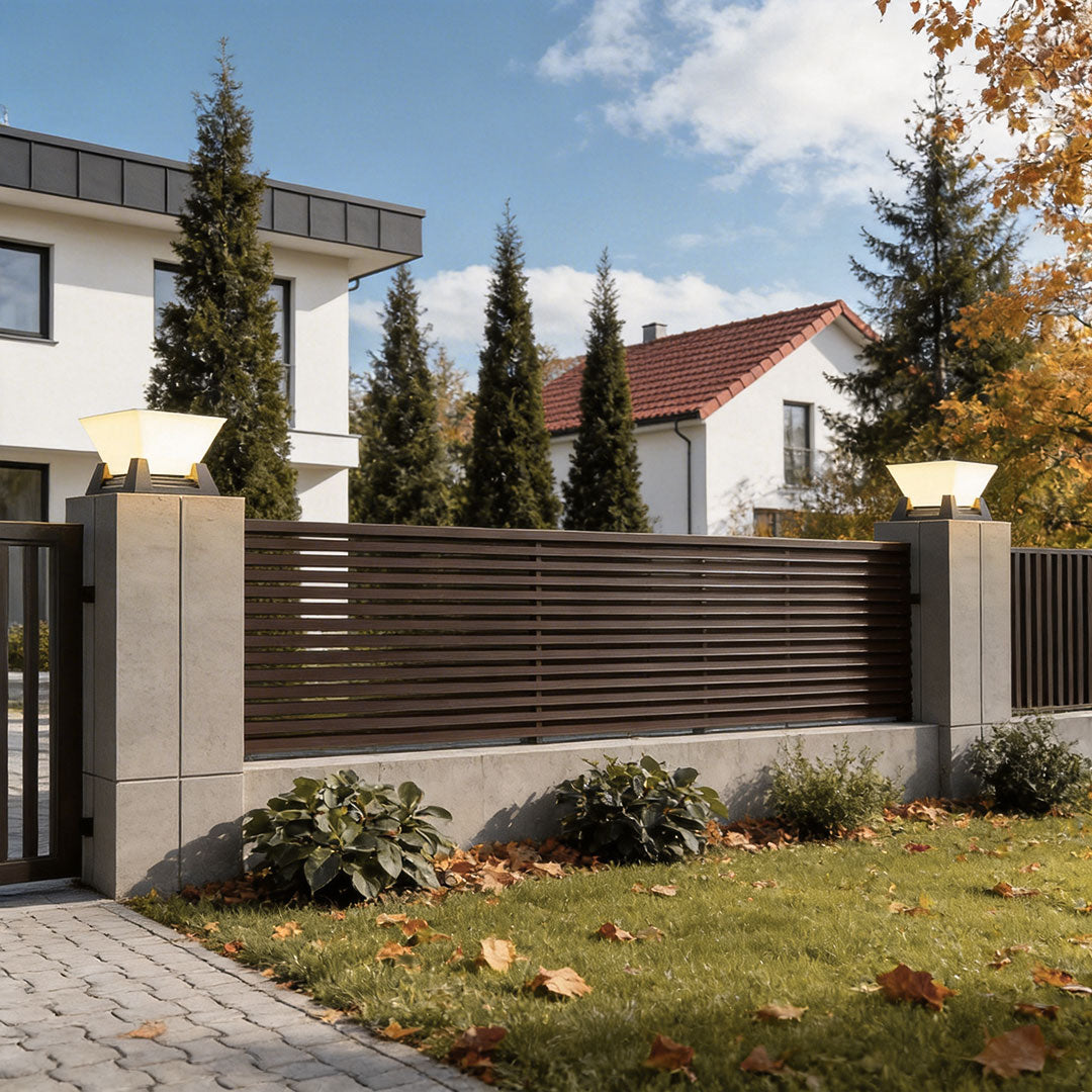 Modern large pillar lights mounted on stone pillars at the entrance of a contemporary home.