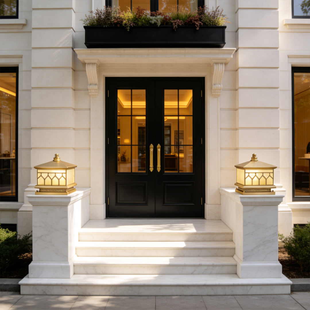 Large solar pillar lights enhancing a grand front entrance with warm luxury outdoor illumination.