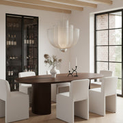 Large tiered silver mesh chandelier over a dark wood oval dining table in a modern dining room.