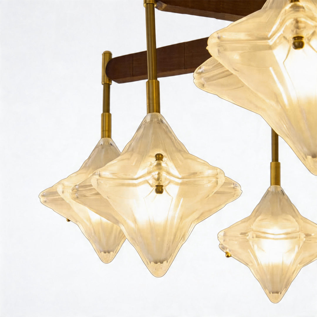 Close-up of vintage gold chandelier showing faceted glass shades and warm glowing bulbs.