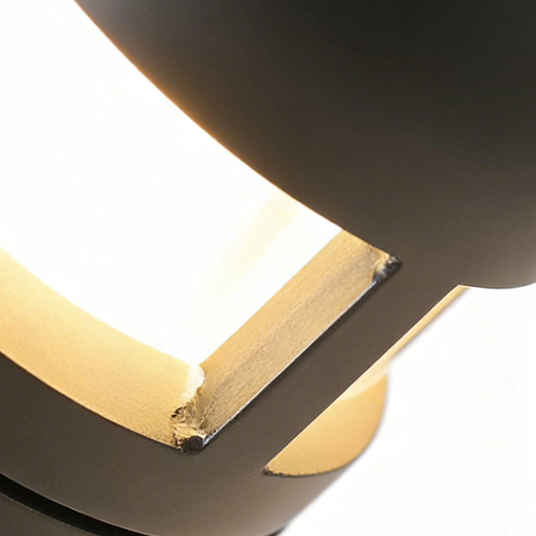 Close-up of contemporary outdoor sconces lights showcasing layered black design and soft ambient LED lighting.