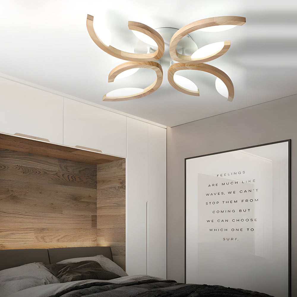 Bedroom interior with a sculptural leaf ceiling light casting warm light and highlighting wood and fabric textures.