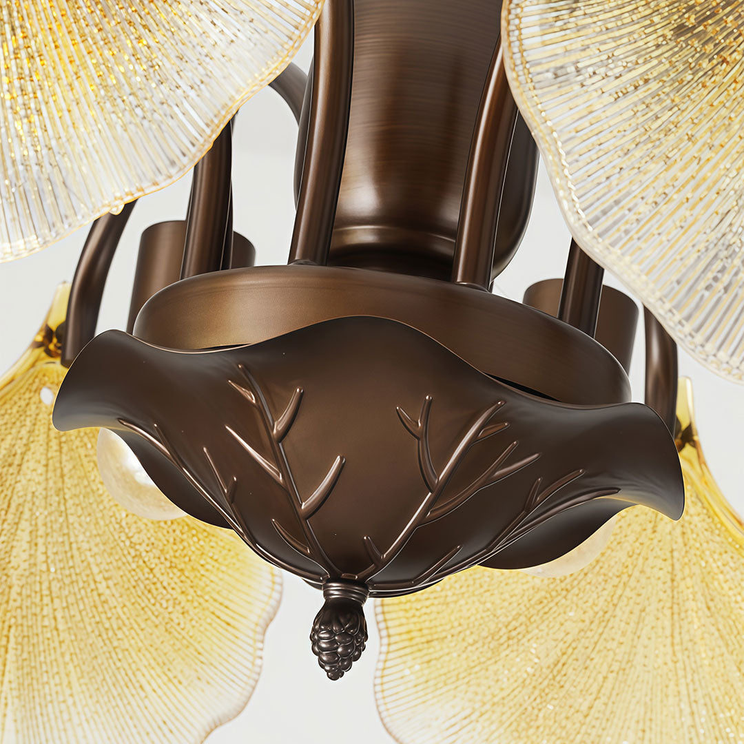 Close-up of leaf glass chandelier showing the sculpted bronze frame and illuminated glass leaves.