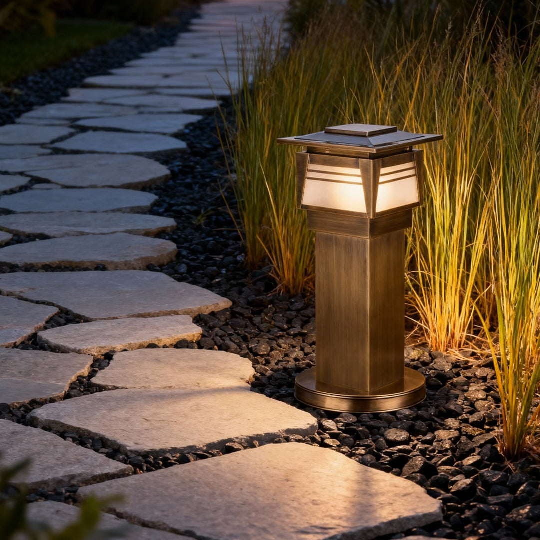 Outdoor LED bollard garden lights placed beside a curved walkway, providing warm accent lighting for garden pathways.