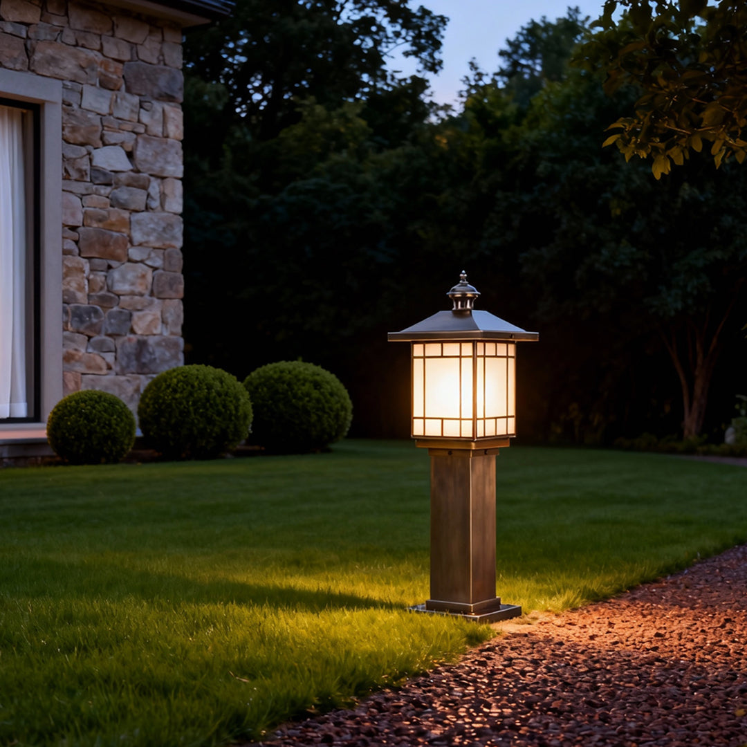 LED bollard landscape lighting positioned on a lawn edge near a home exterior, offering warm and welcoming outdoor light.