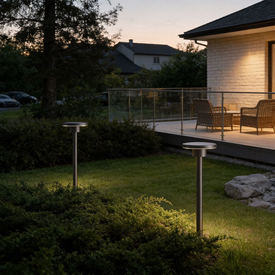 LED bollard path lights with a modern design, providing warm illumination near a patio.