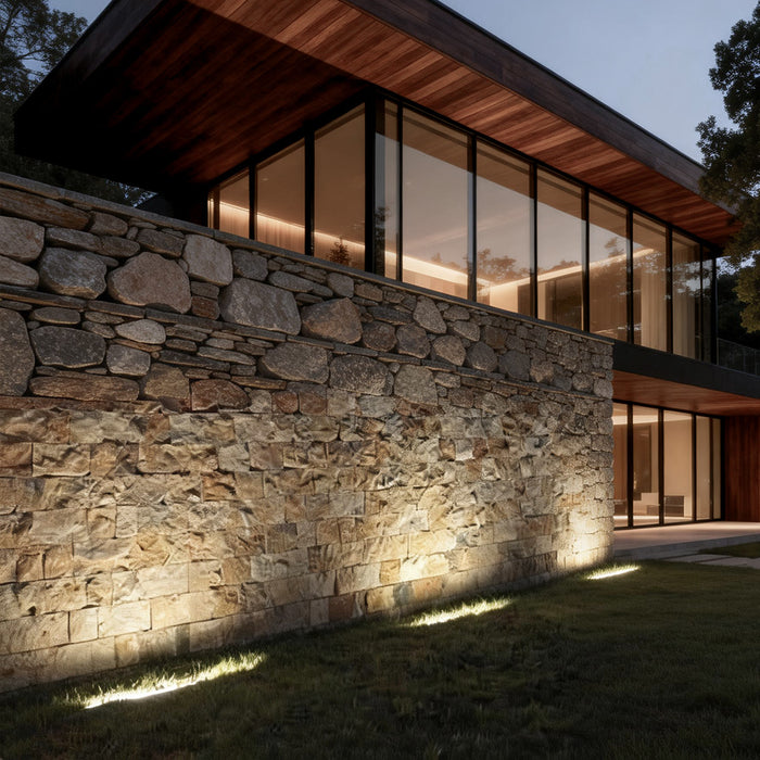 LED building facade lighting illuminating a modern house exterior with warm glow and stone wall texture.