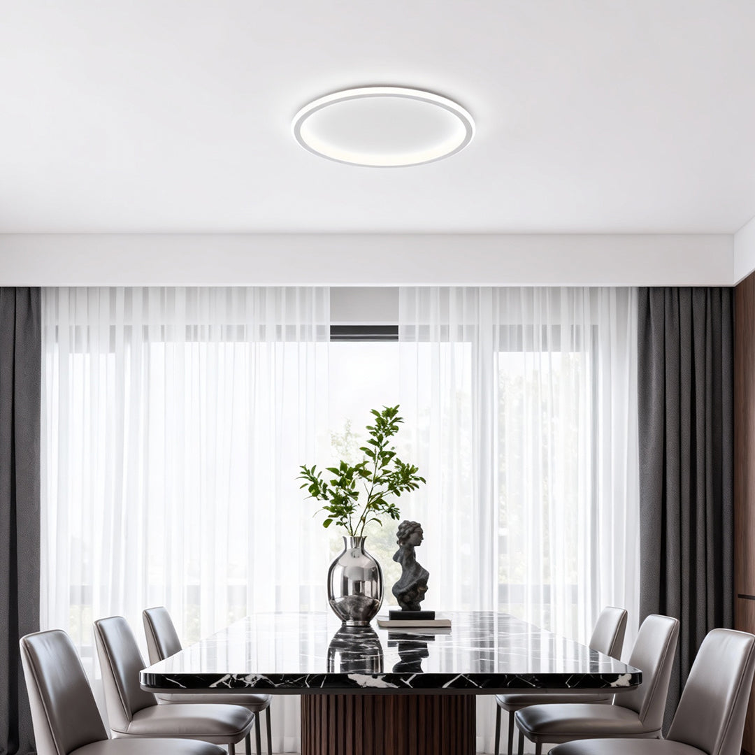 Minimalist dining area illuminated by a flush mount led circle ceiling lamp with clean lines.