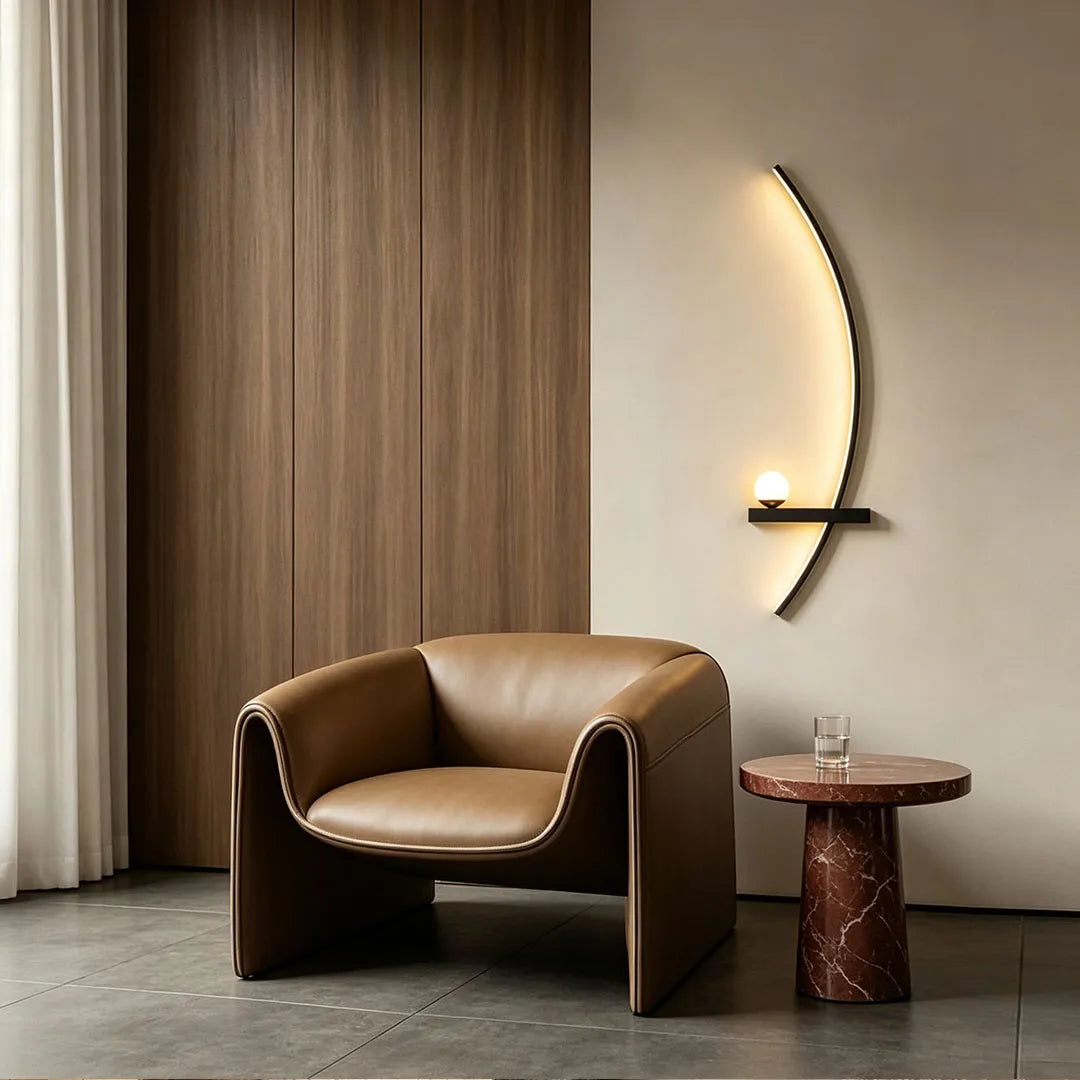 LED curved wall light displayed beside a leather lounge chair and side table in a contemporary interior.