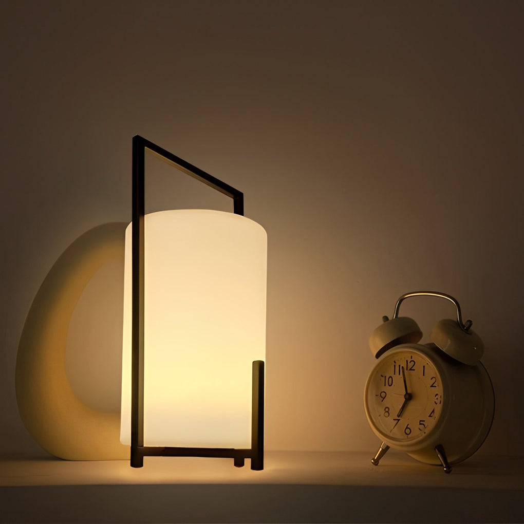 LED cylinder light fixture with a black frame, illuminating a nightstand.