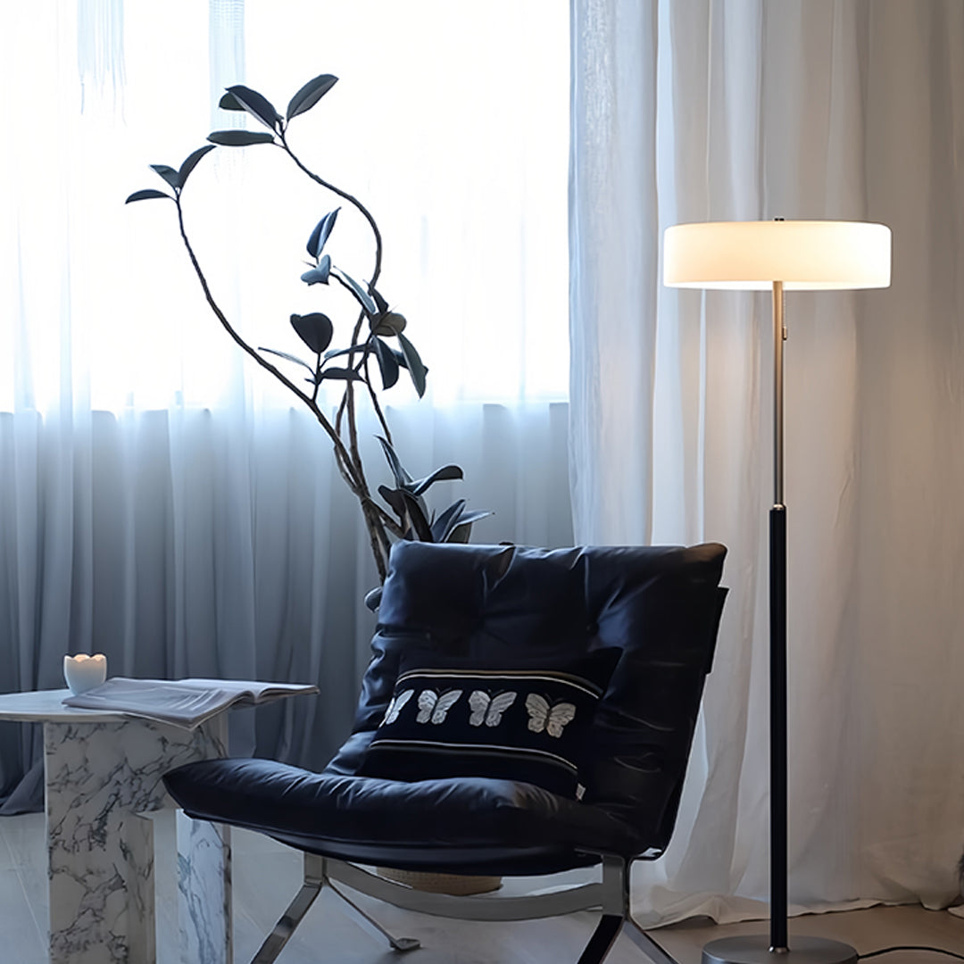 LED floor lamp positioned next to dark leather chair in contemporary room setting