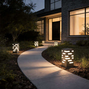 LED garden bollard lights illuminating a modern driveway with warm directional glow.