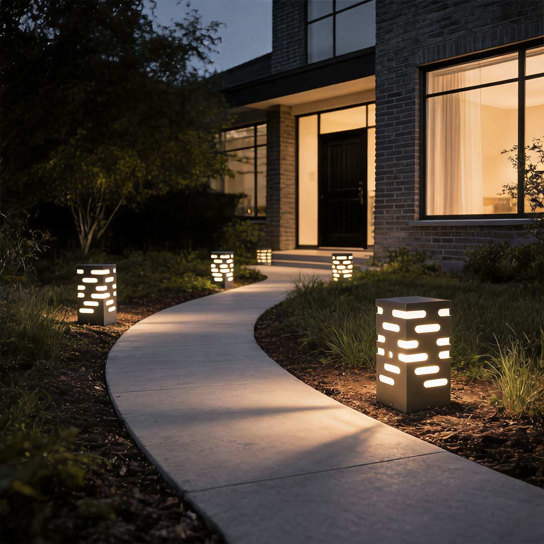 LED garden bollard lights illuminating a modern driveway with warm directional glow.