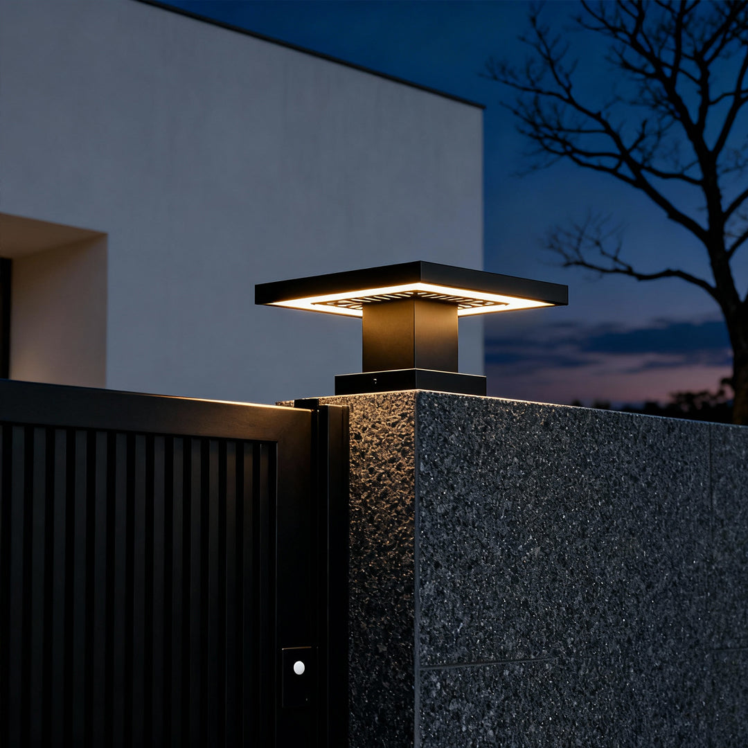 Tall concrete gate pillar fitted with a led gate pillar light producing warm directional lighting.