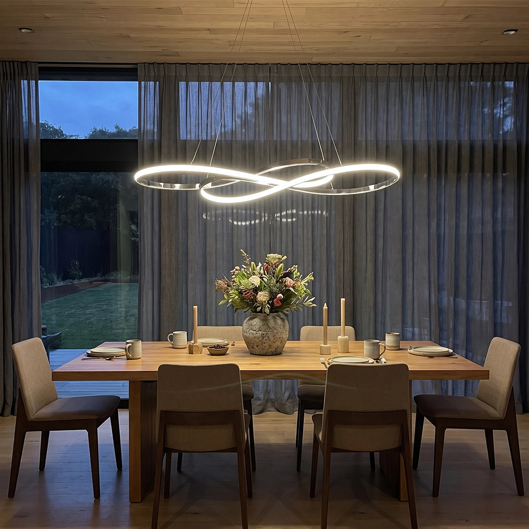 LED infinity chandelier hanging above a dining table, creating a sculptural focal point in a modern dining room.