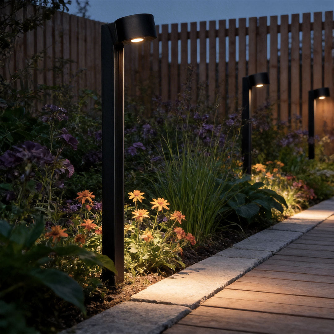 LED landscape path lighting placed along a modern paved walkway with lush planting borders.