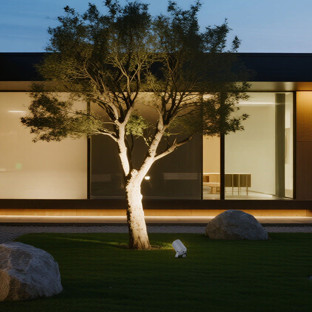 LED landscape spotlight creating dramatic tree uplighting in modern residential courtyard setting