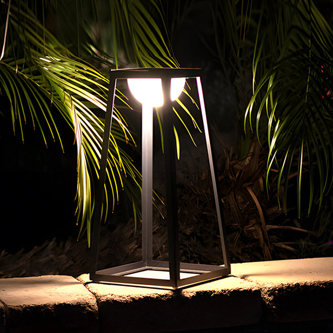 Contemporary LED lantern creating atmospheric lighting among lush palm fronds at night