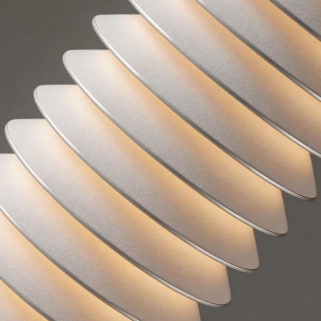 LED light bollard with a layered design, providing soft illumination near a sofa.