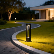 LED light bollard illuminating a modern garden pathway with warm directional glow.